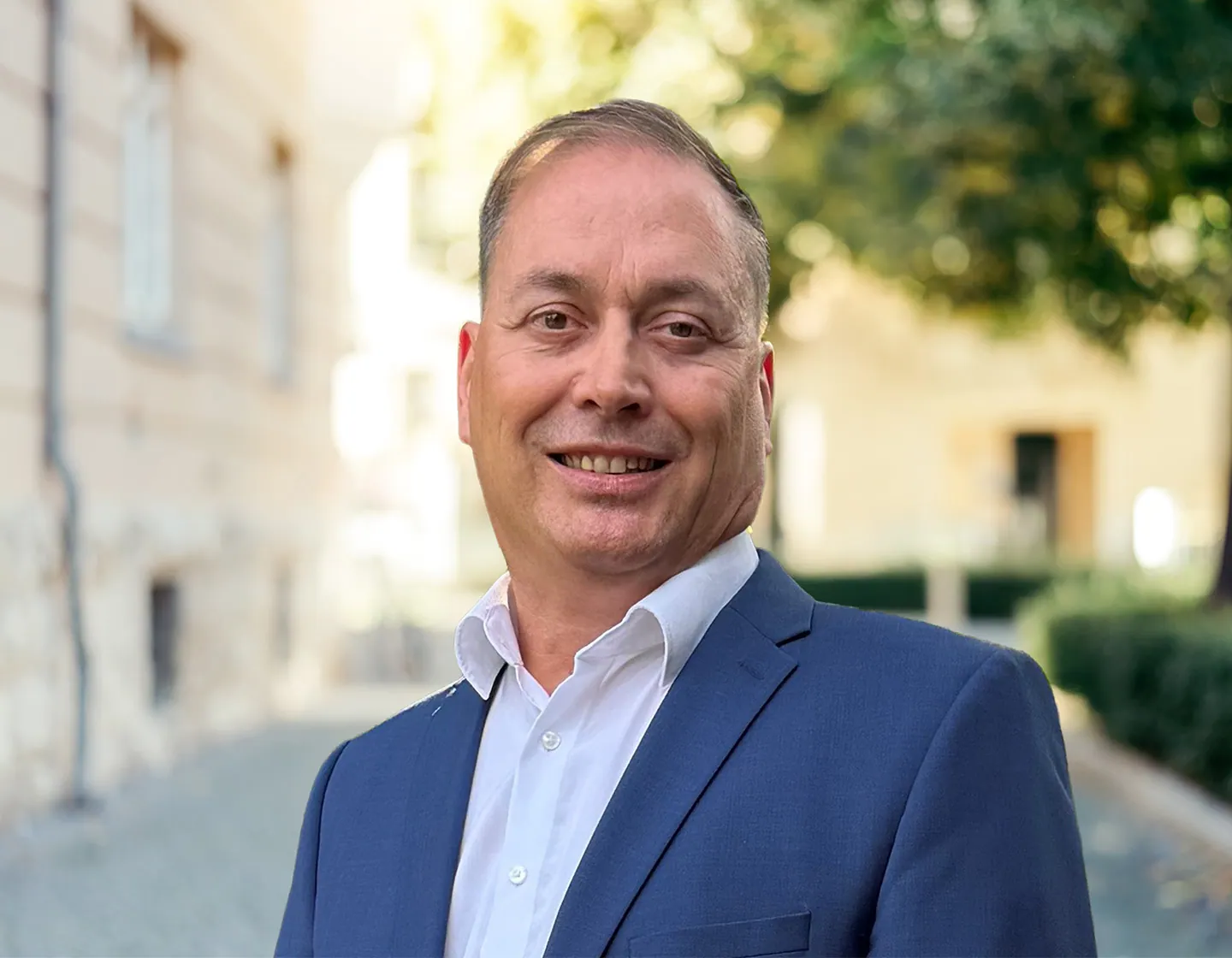 Porträt des Immobilienmaklers Jozep Zivko im blauen Sakko