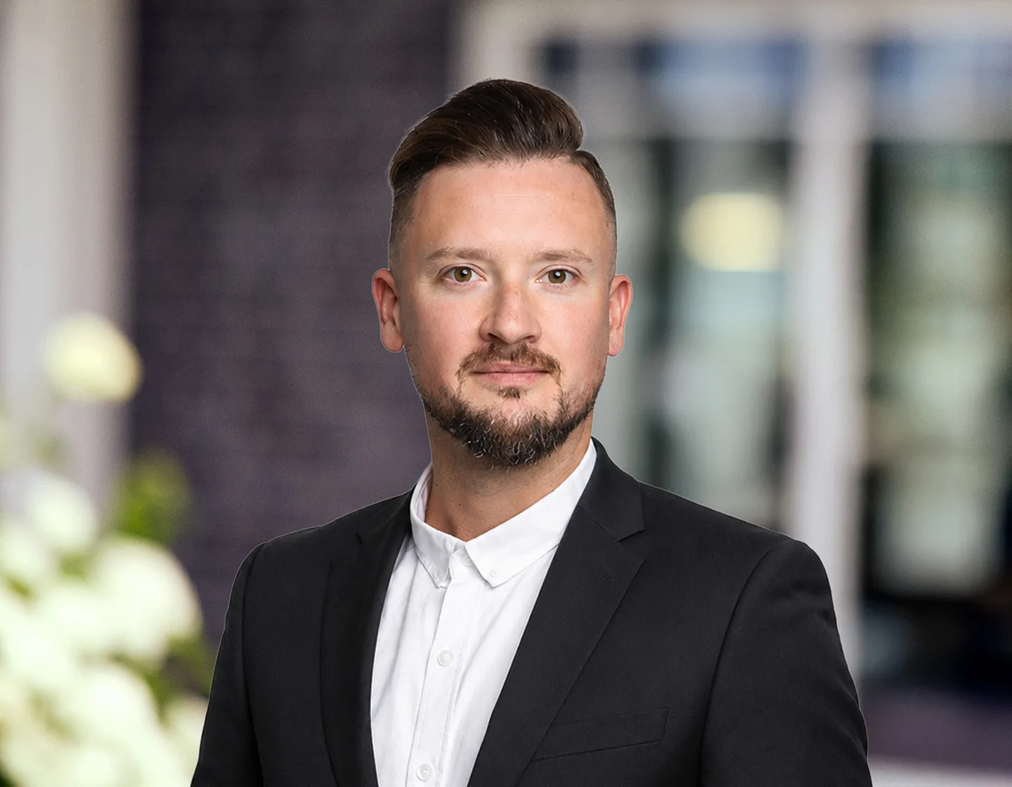 Porträt des Immobilienmaklers Nico Gutzeit im schwarzen Sakko und weißem Hemd